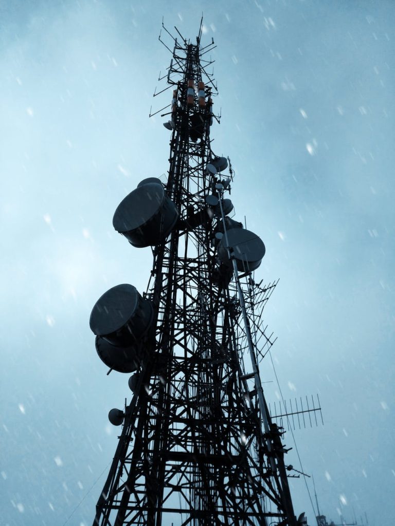 black satellite tower under blue skies