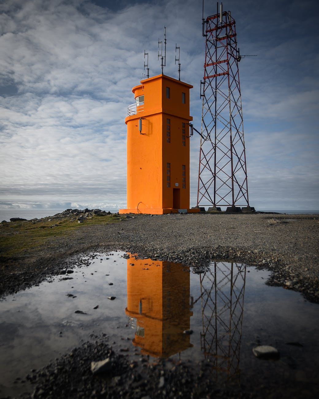 orange tower beside metal tower during day