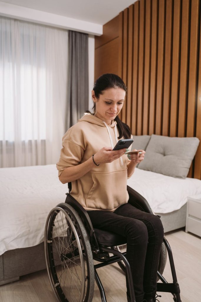 woman on wheelchair holding a cellphone